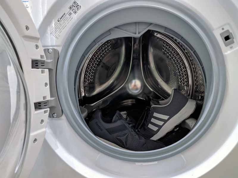 Open washing machine drum being checked mid-repair