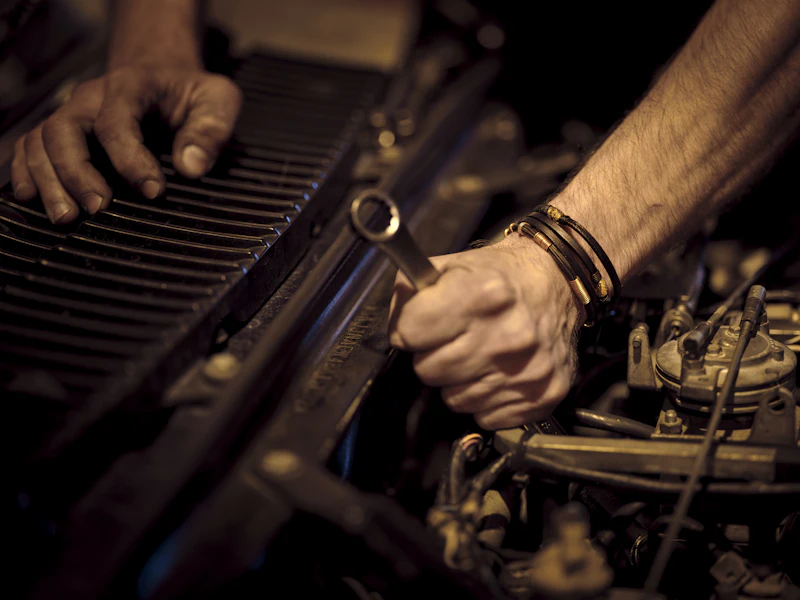 Mechanic’s hands working on an engine with a spanner