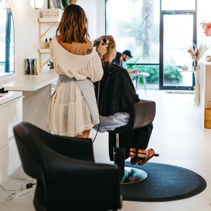 Stylist finishing a client’s blow-dry at the chair