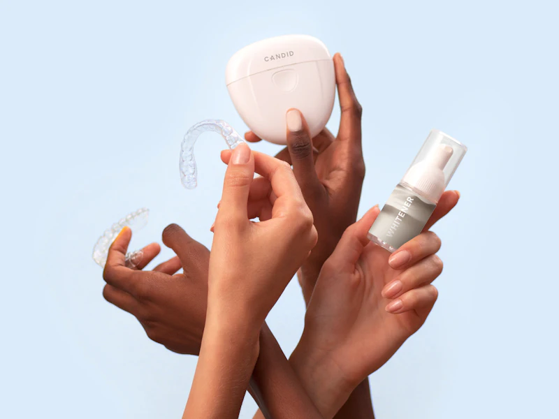 Hands holding a set of clear dental aligners