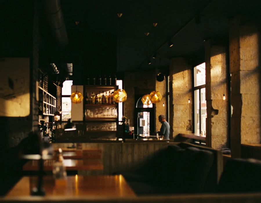 Warm, low-lit dining room with pendant lights and wooden tables